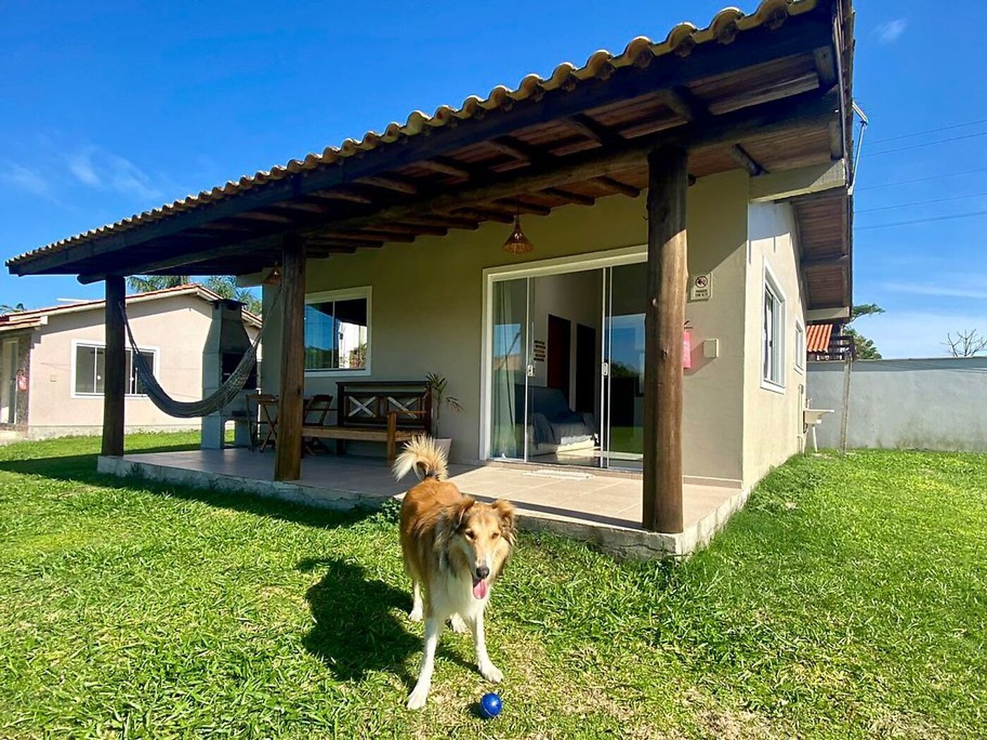 Casa com varanda de madeira e amplo gramado na Morada Carmem