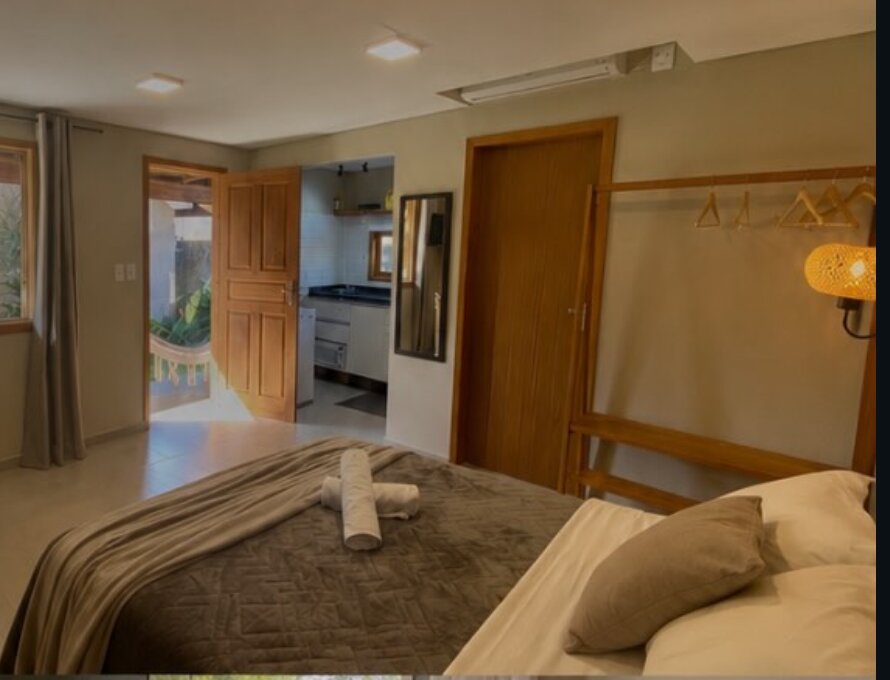 Studio com cama de casal, cozinha compacta e saída para a varanda